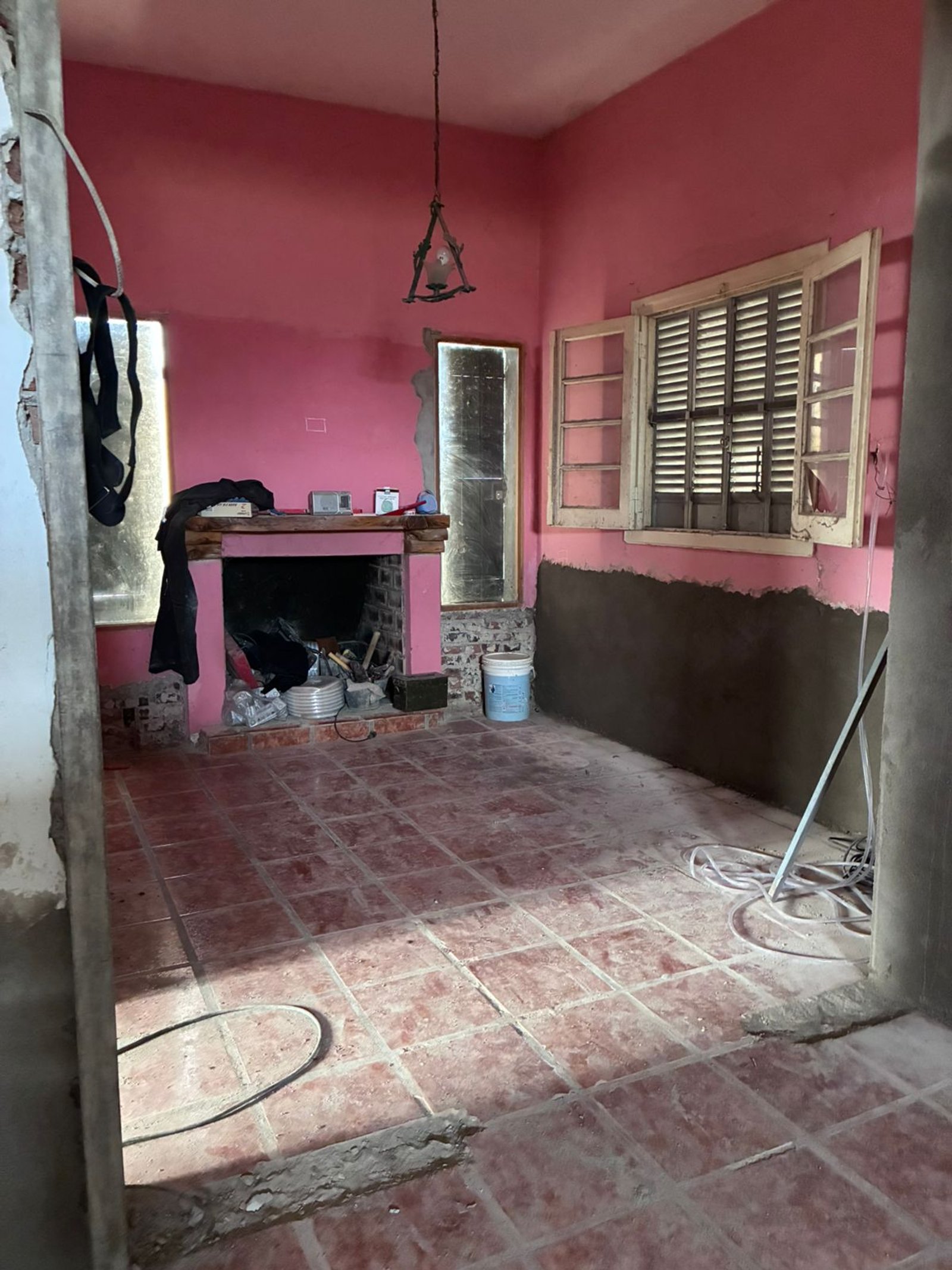 Quarto em reforma com paredes cor-de-rosa e lareira — projeto Chacra JE, por Atelier de Diseño Interior - Luján Macia, em Río Colorado